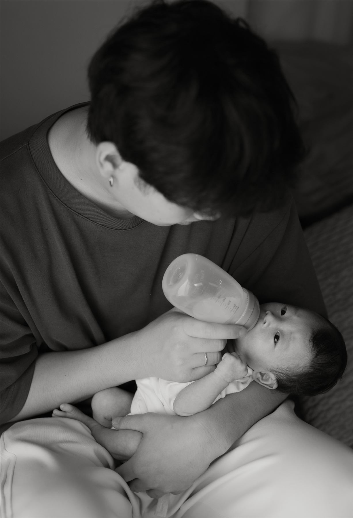 哺乳瓶で赤ちゃんに授乳する家族
