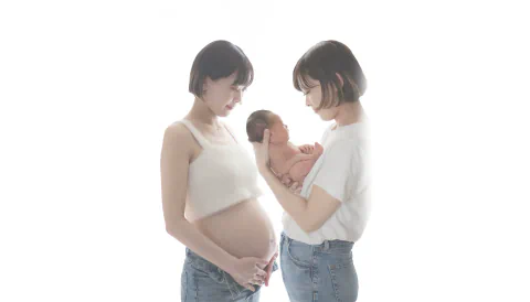 妊娠中のお母さまと新生児を抱くお母さまをつないだ家族写真